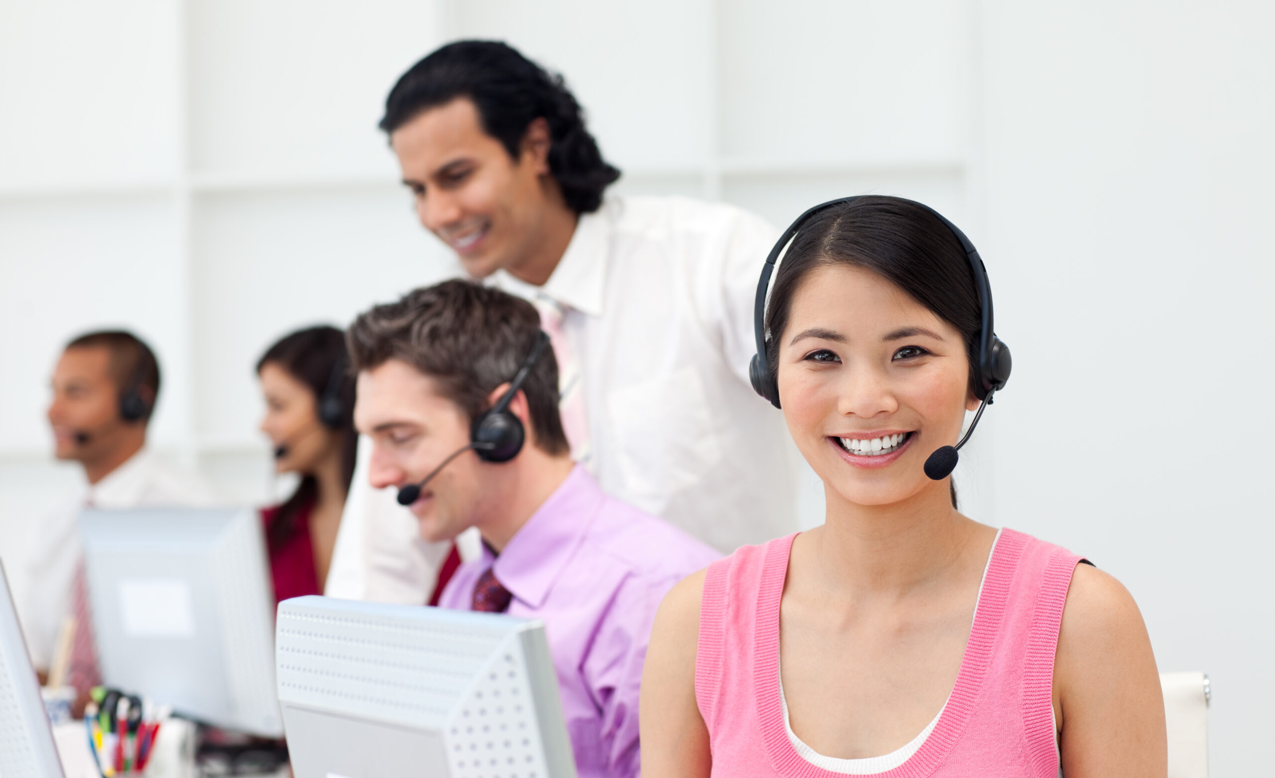 Ethnic manager checking his employee's work in a call center