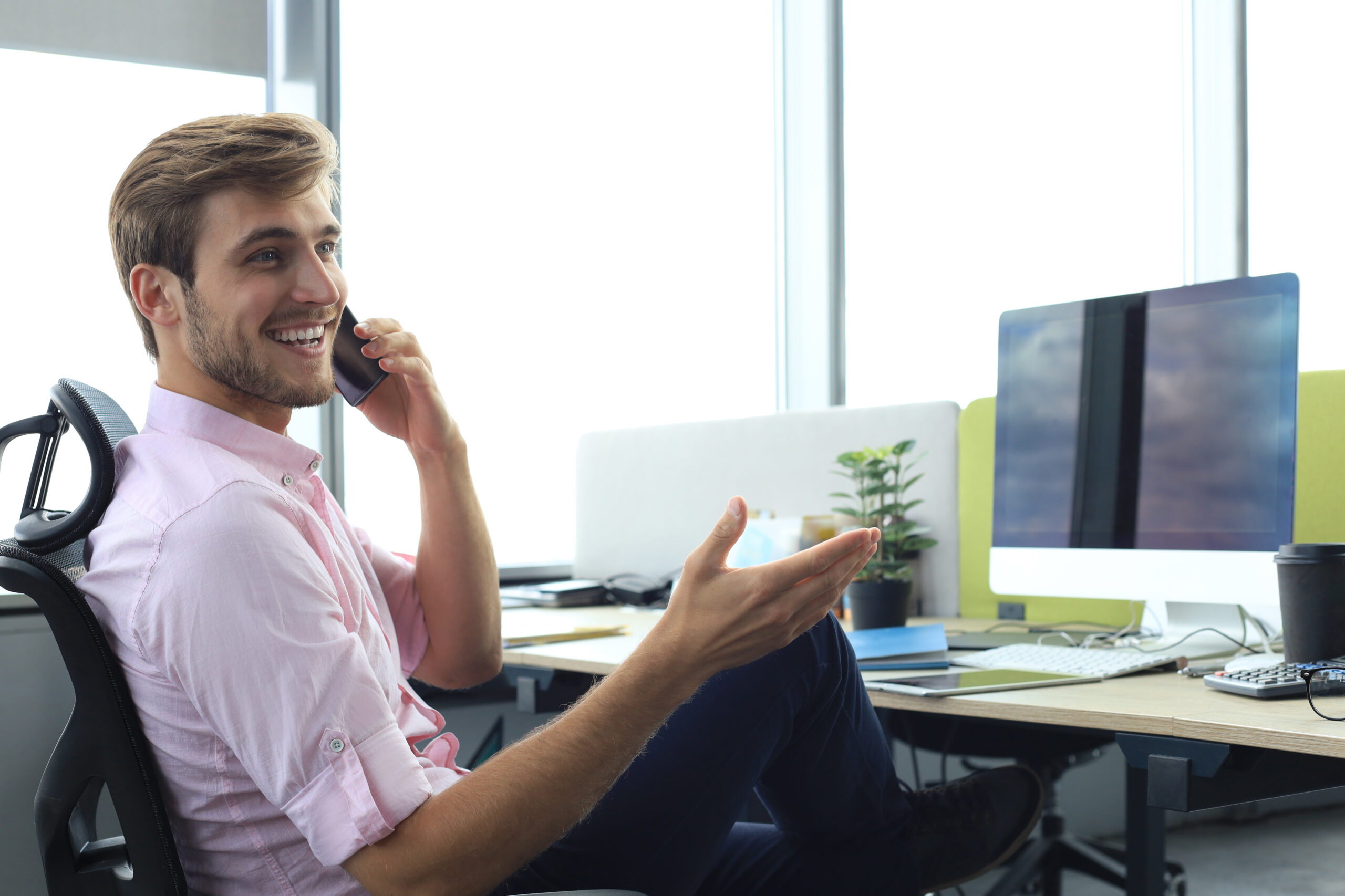 Modern businessman talking on the phone while sitting in the office